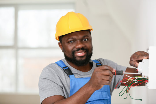 Skilled electrician installing fixtures